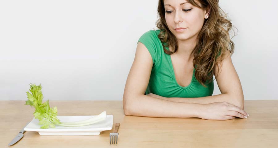 Woman at a table who is food deprived