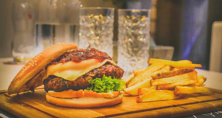 Burgers and fries on a wooden plate
